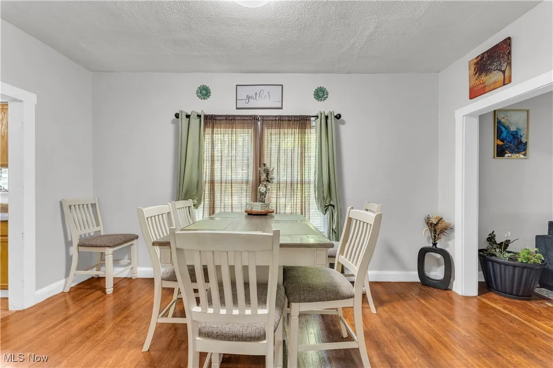 Dining room featuring light wood-type flooring and a textured ceiling