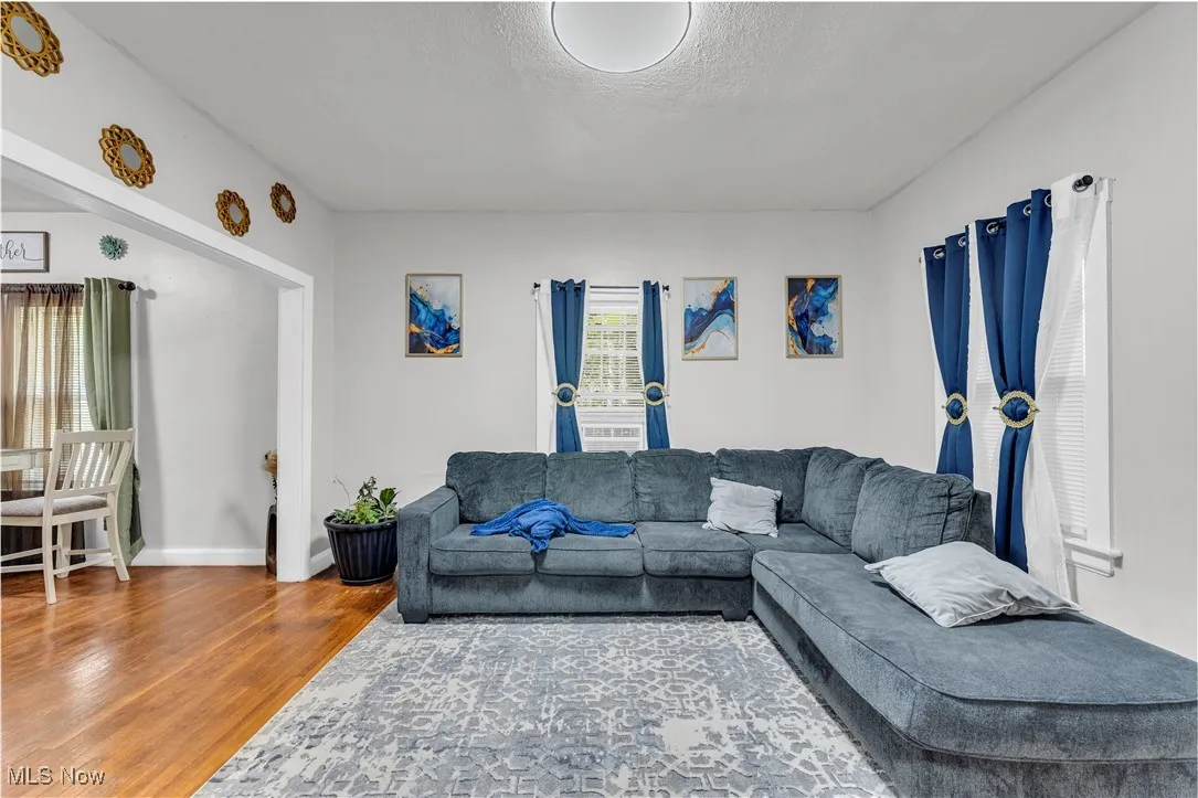Living area featuring wood finished floors and a textured ceiling