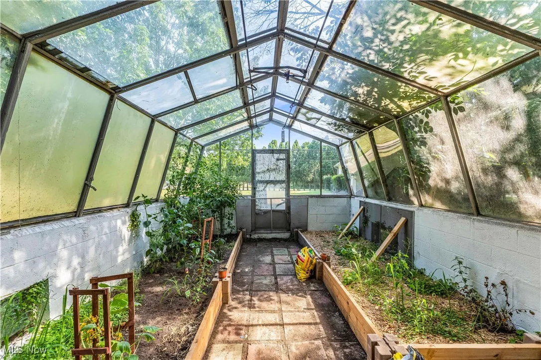 Unfurnished sunroom featuring lofted ceiling
