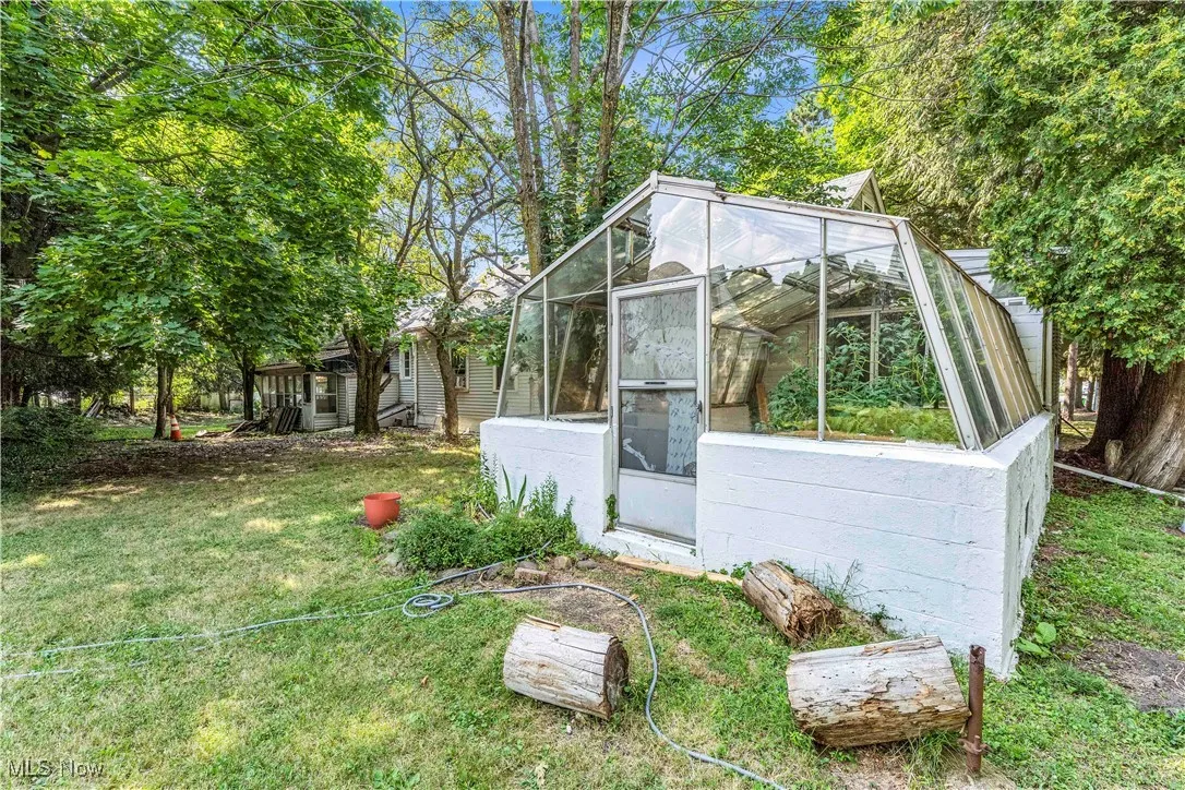 View of greenhouse featuring a sunroom and a yard
