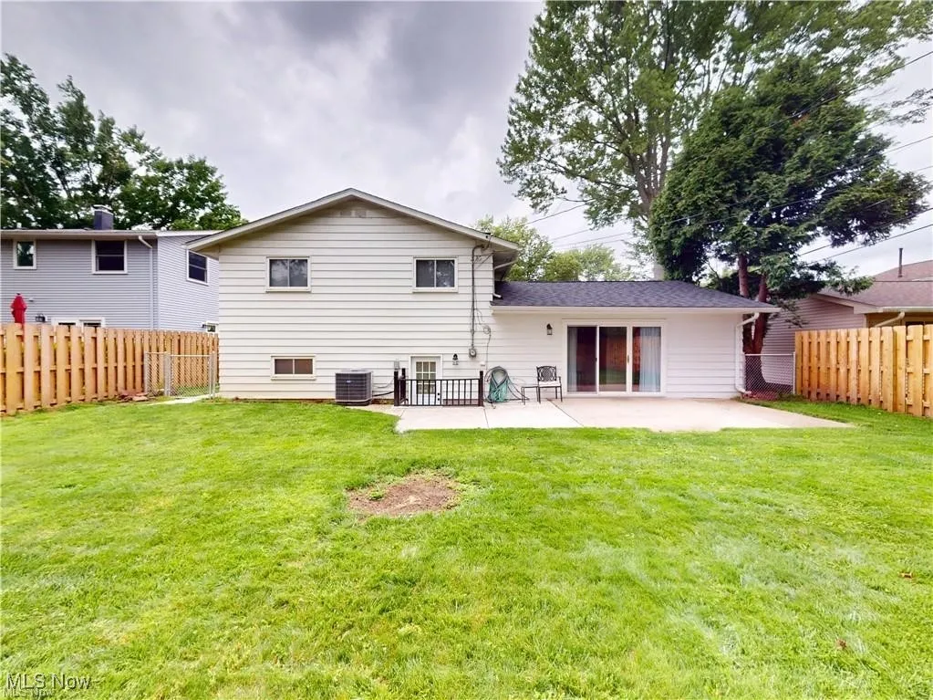 Back of property featuring a fenced backyard and a patio