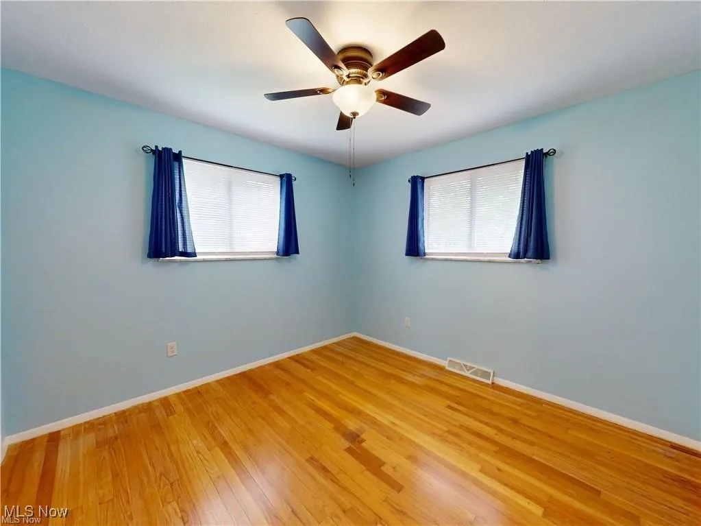 Empty room featuring hardwood / wood-style floors and ceiling fan