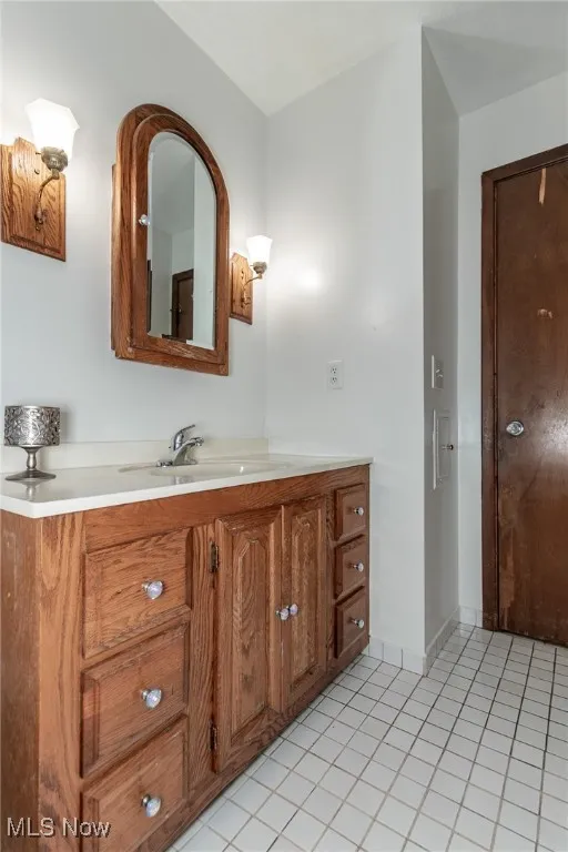 Bathroom with light tile patterned floors and vanity