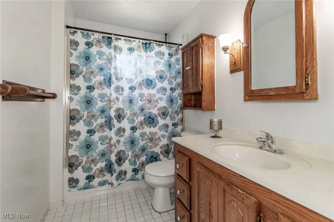 Bathroom with vanity, light tile patterned floors, and shower / bath combo