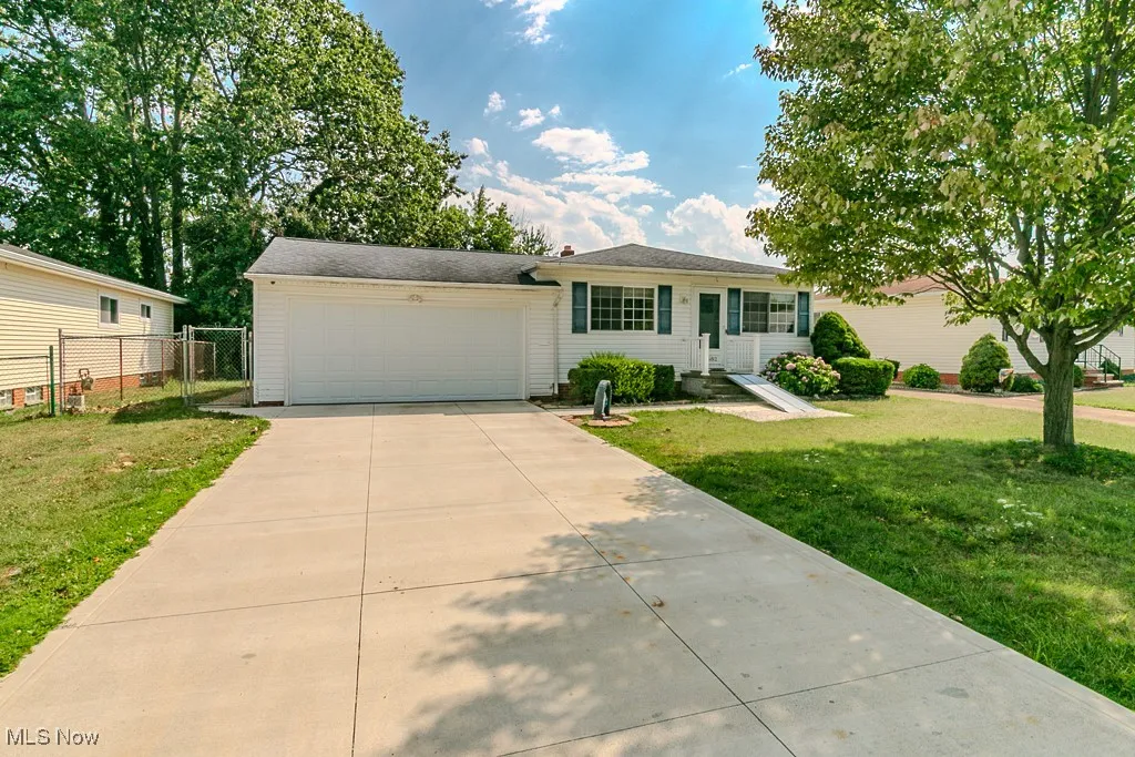 Single story home featuring a front lawn, a garage, and driveway