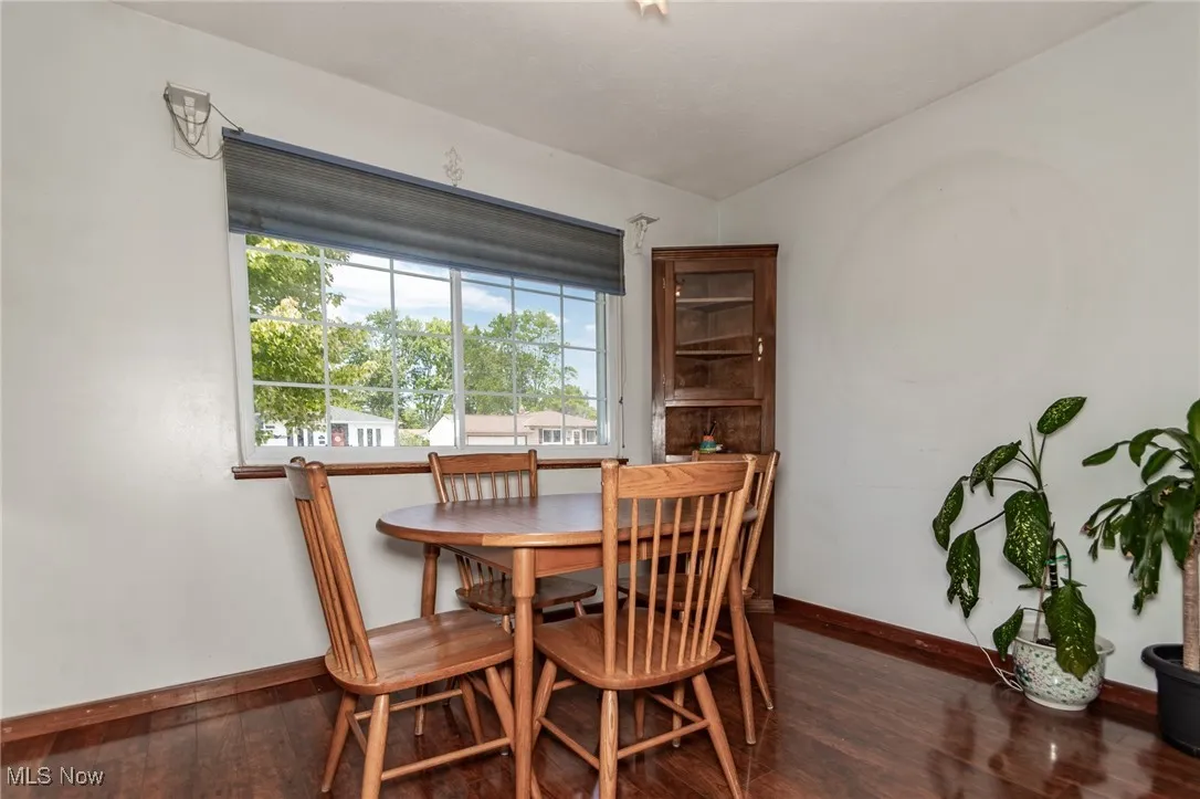 Dining room featuring dark wood finished floors and baseboards