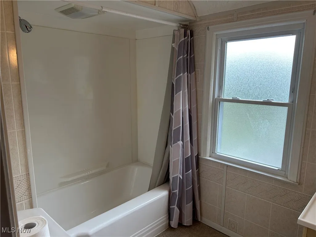 Bathroom with plenty of natural light and shower / tub combo