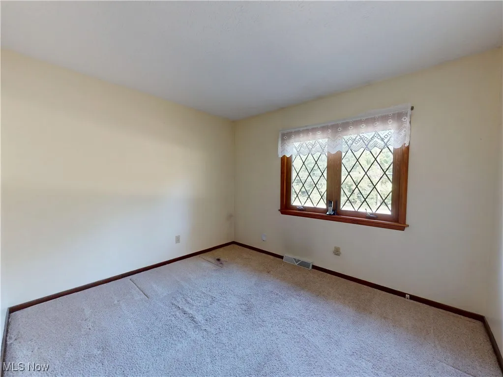 Empty room with carpet flooring and baseboards