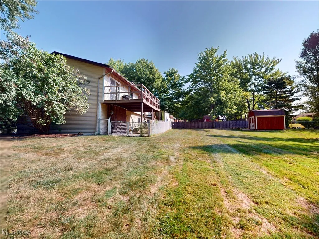 View of yard featuring a wooden deck and a shed