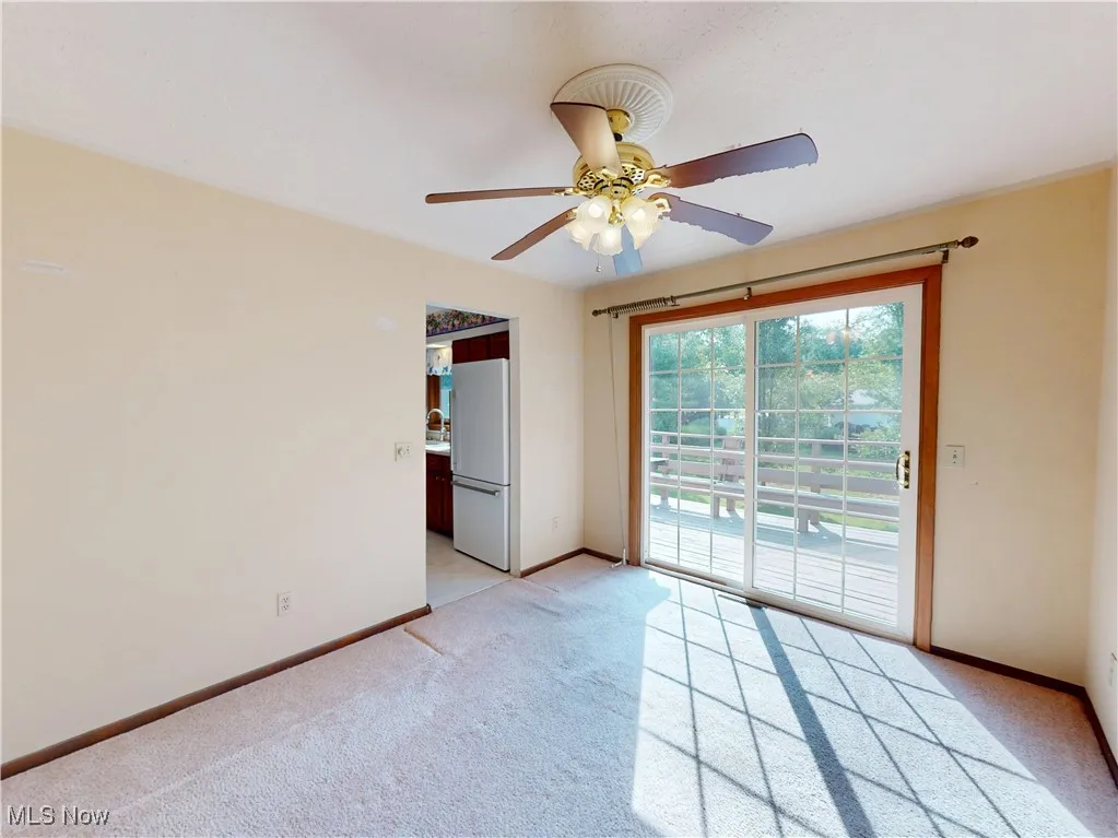 Unfurnished room featuring light colored carpet and ceiling fan