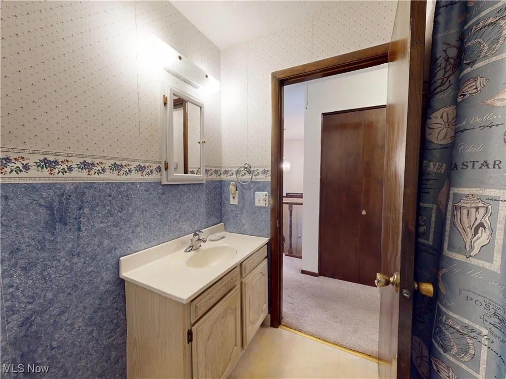 Bathroom featuring vanity and wallpapered walls