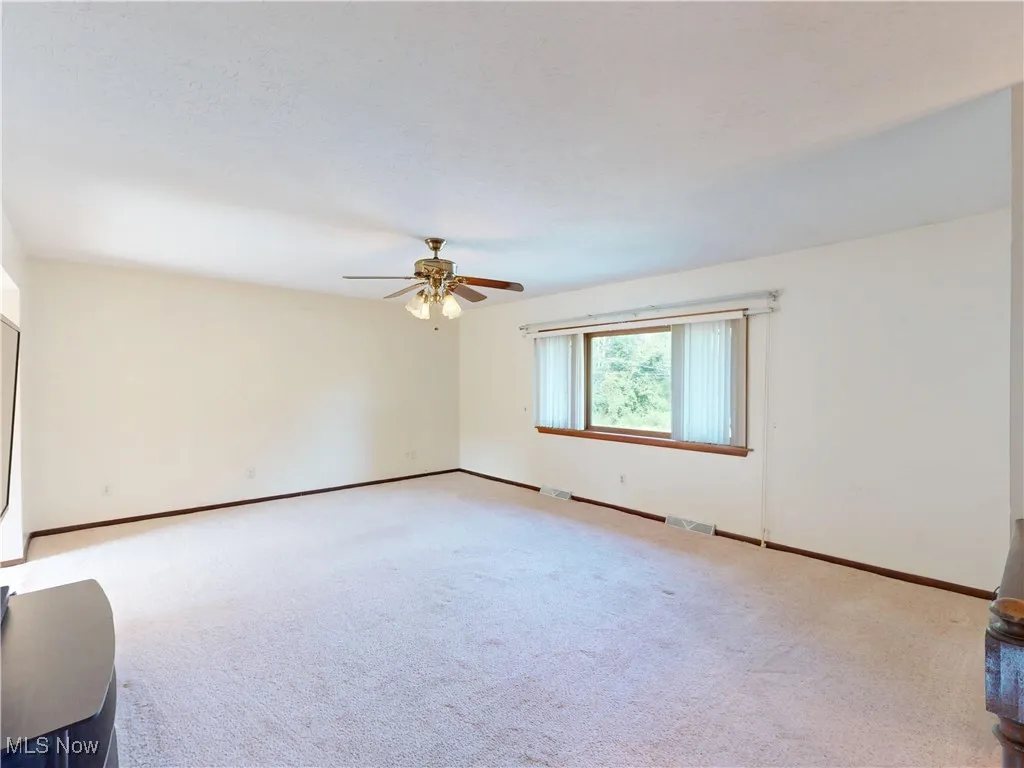 Unfurnished room with carpet flooring and a ceiling fan