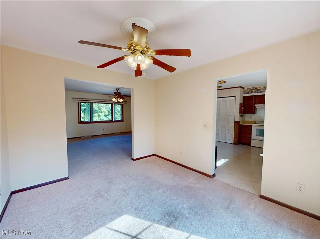 Spare room with light carpet and ceiling fan