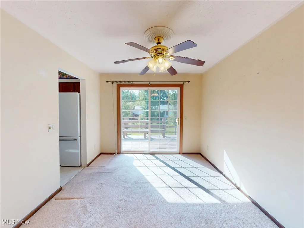 Unfurnished room with light colored carpet and ceiling fan