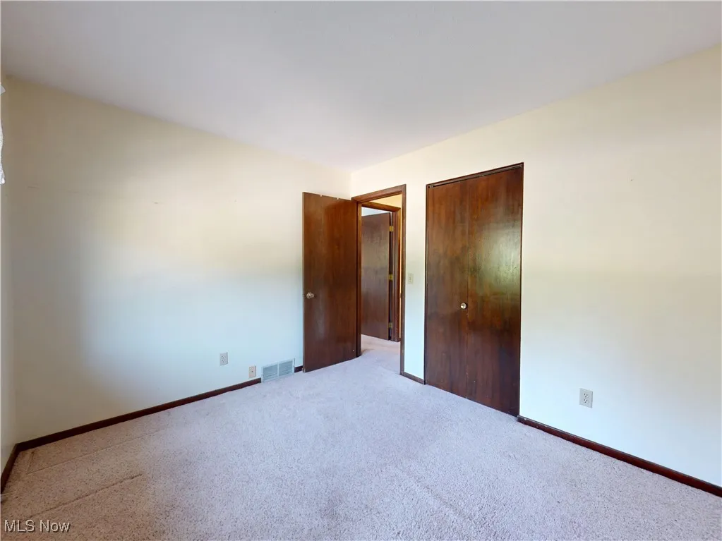 Unfurnished bedroom with a closet and carpet