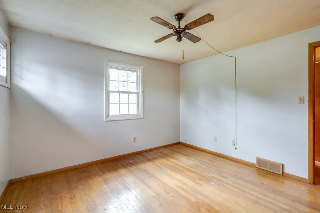 Unfurnished room with light wood-type flooring and a ceiling fan