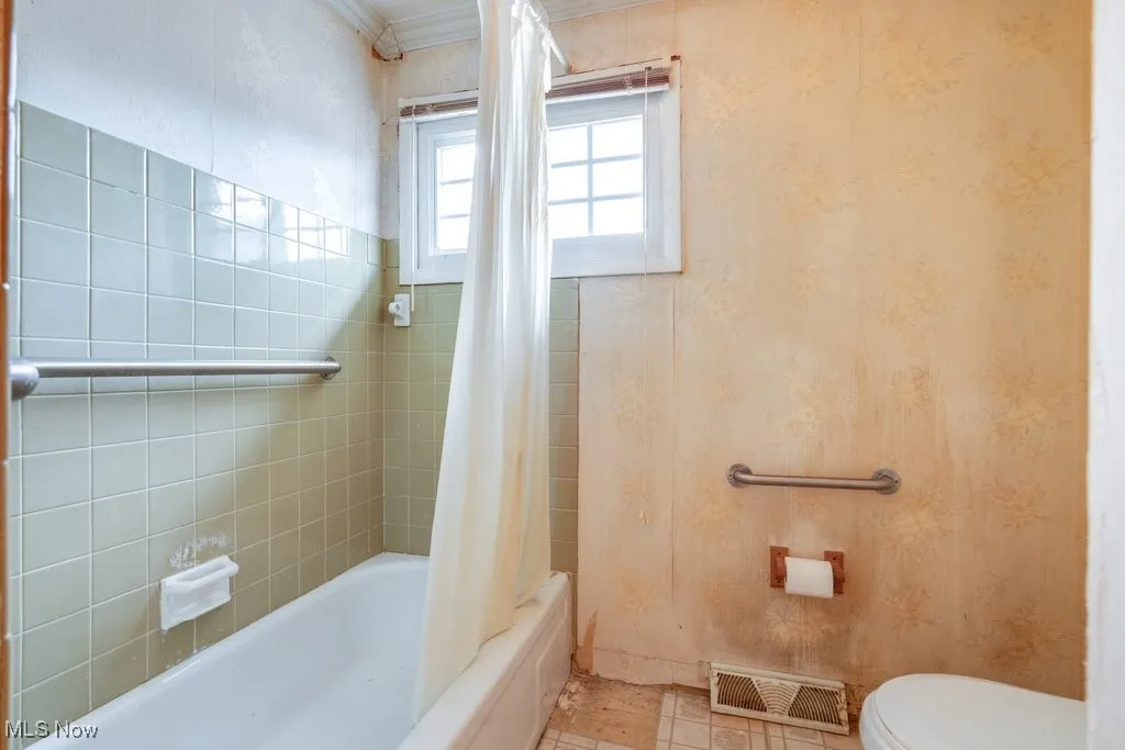 Full bath featuring shower / tub combo with curtain, tile patterned flooring, and crown molding