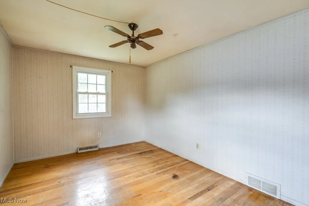 Spare room with light wood-type flooring and ceiling fan