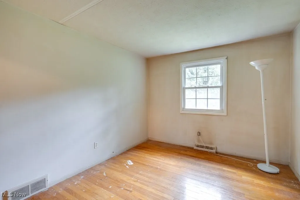 Unfurnished room with light wood-style floors and baseboards