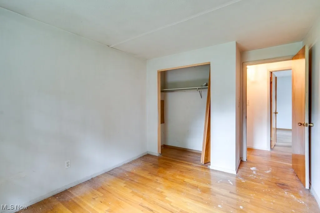 Unfurnished bedroom featuring light wood finished floors and a closet