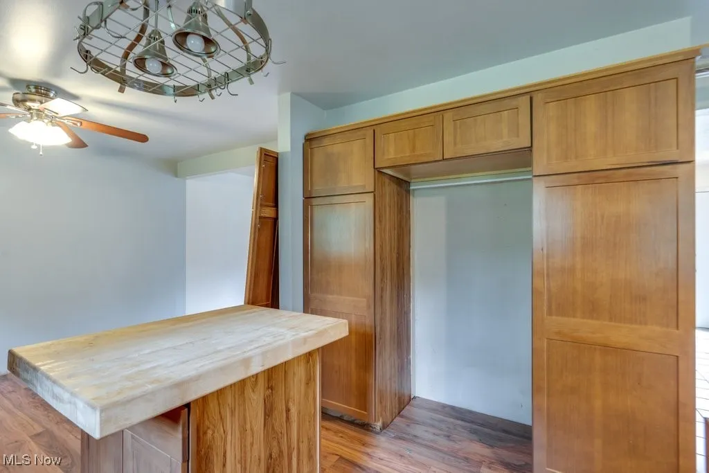 Kitchen featuring butcher block counters, brown cabinets, dark wood-type flooring, and a center island