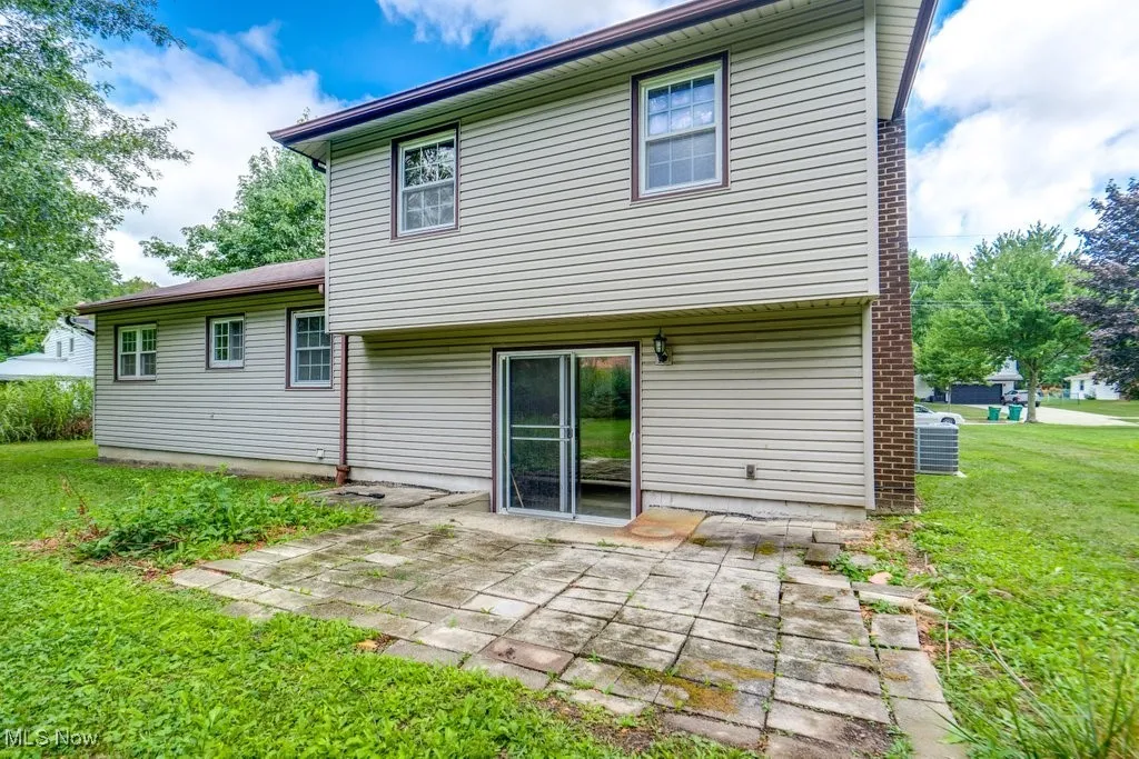 Rear view of house with a yard and a patio area