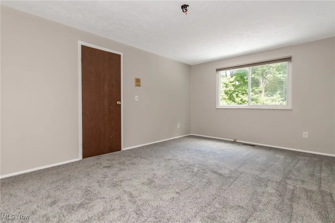 Carpeted spare room with baseboards