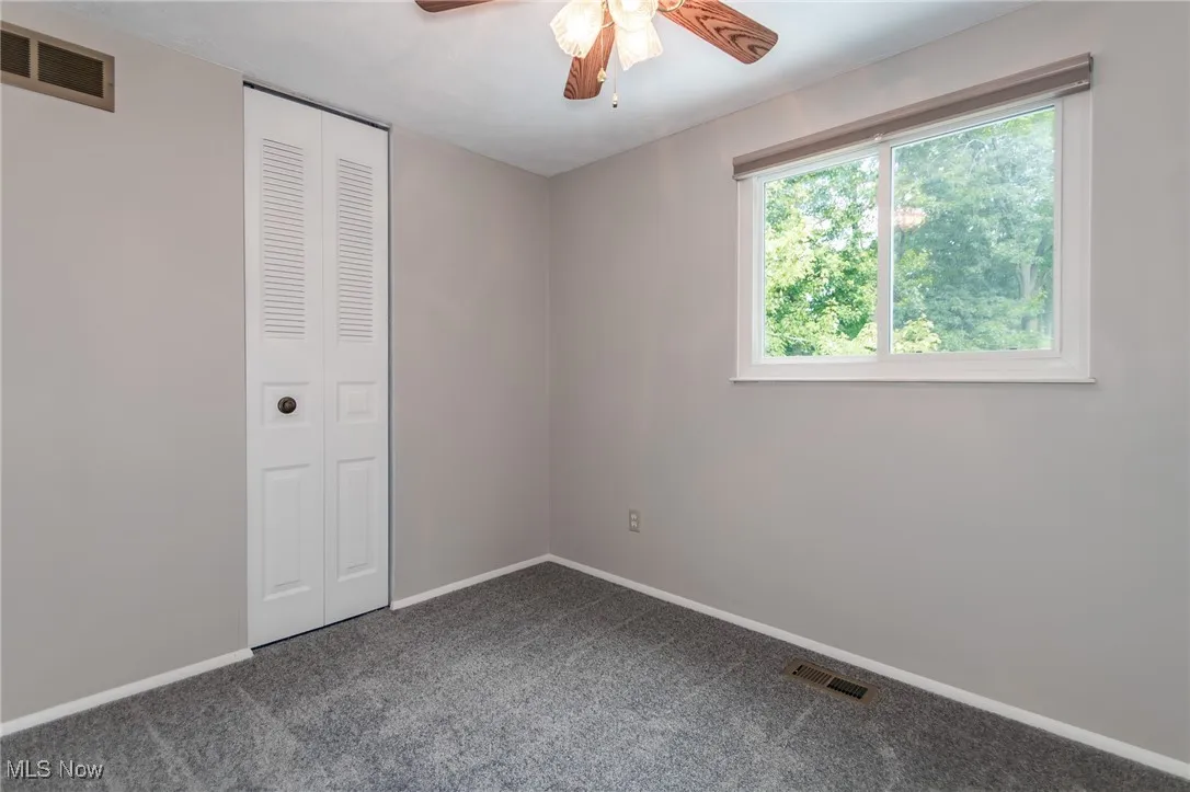 Unfurnished bedroom with carpet flooring, a closet, and a ceiling fan