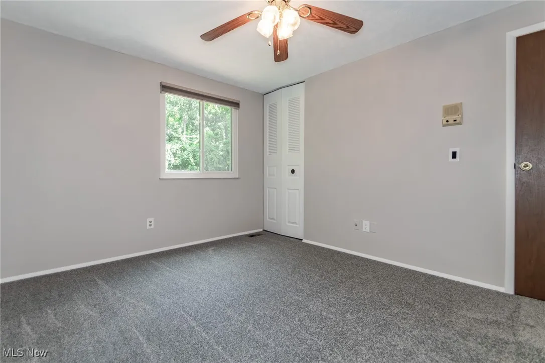 Empty room featuring carpet and a ceiling fan