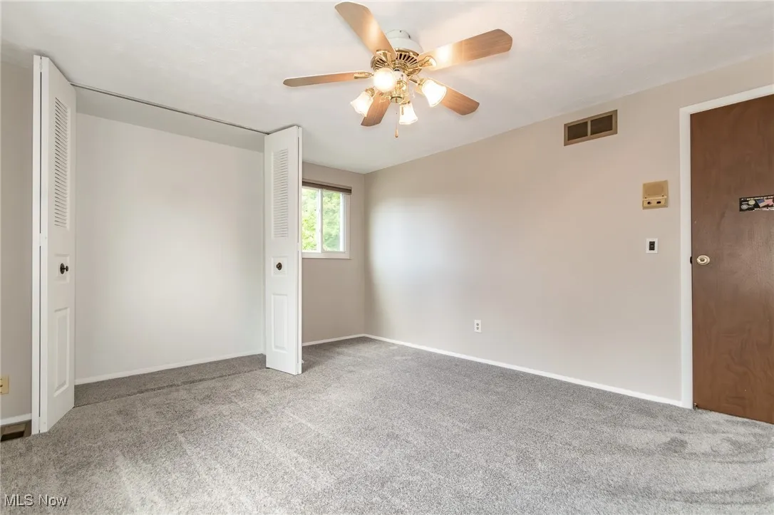 Unfurnished bedroom with carpet flooring, ceiling fan, and a closet