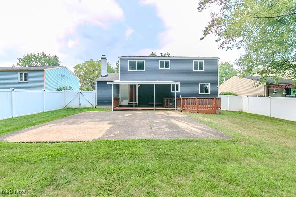 Rear view of house featuring a fenced backyard and a chimney