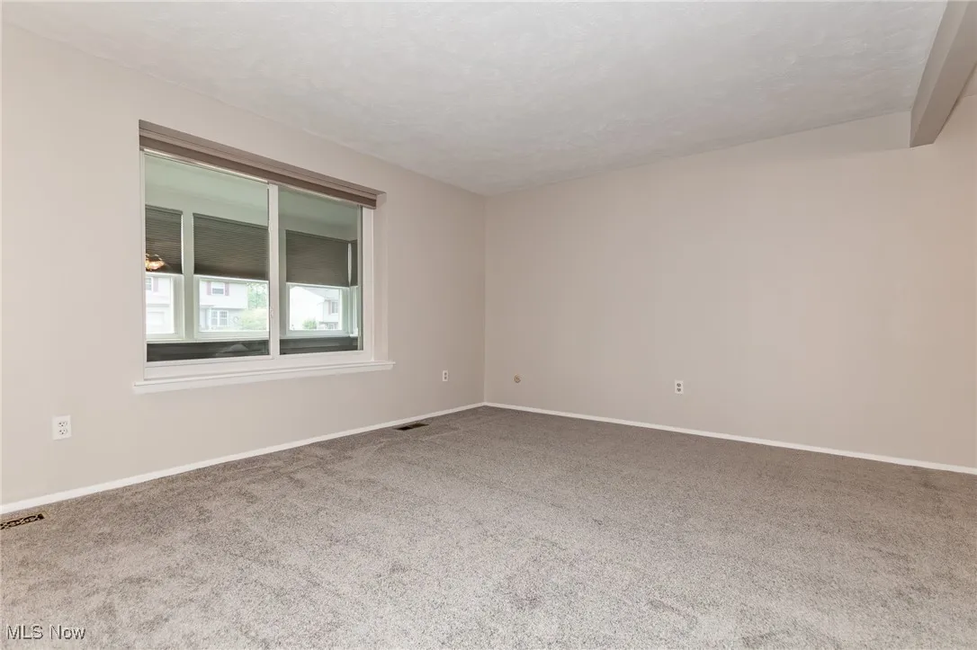 Carpeted spare room with baseboards and a textured ceiling