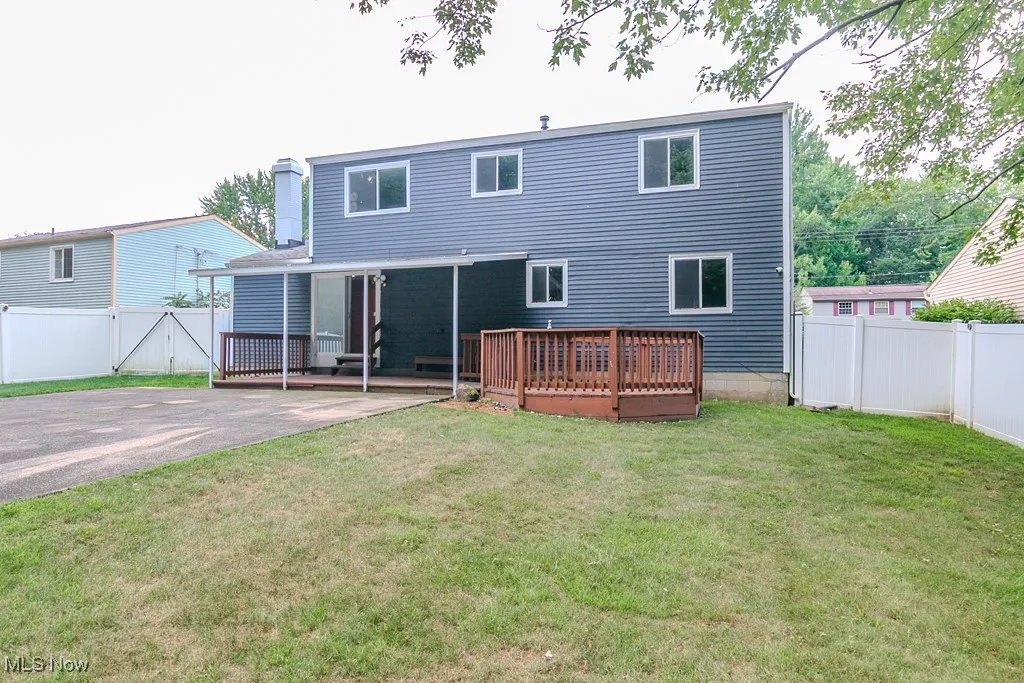 Back of property featuring a fenced backyard, and a wooden deck
