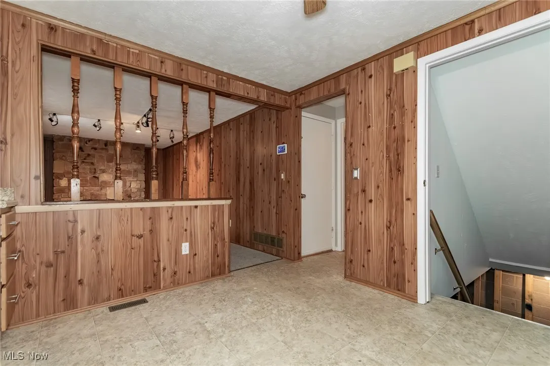 View from in the kitchen looking toward the family room with a stone fireplace