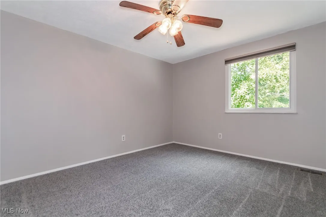 Empty room with carpet floors and ceiling fan