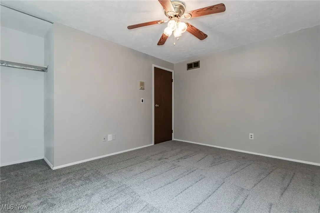 Unfurnished bedroom with carpet floors and ceiling fans