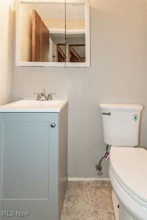 Half bathroom featuring vanity and light tile patterned floors