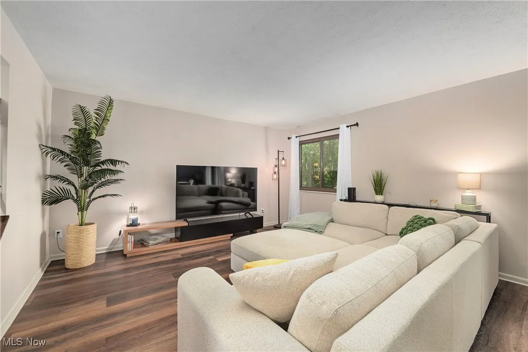 Living area with dark wood finished floors and baseboards
