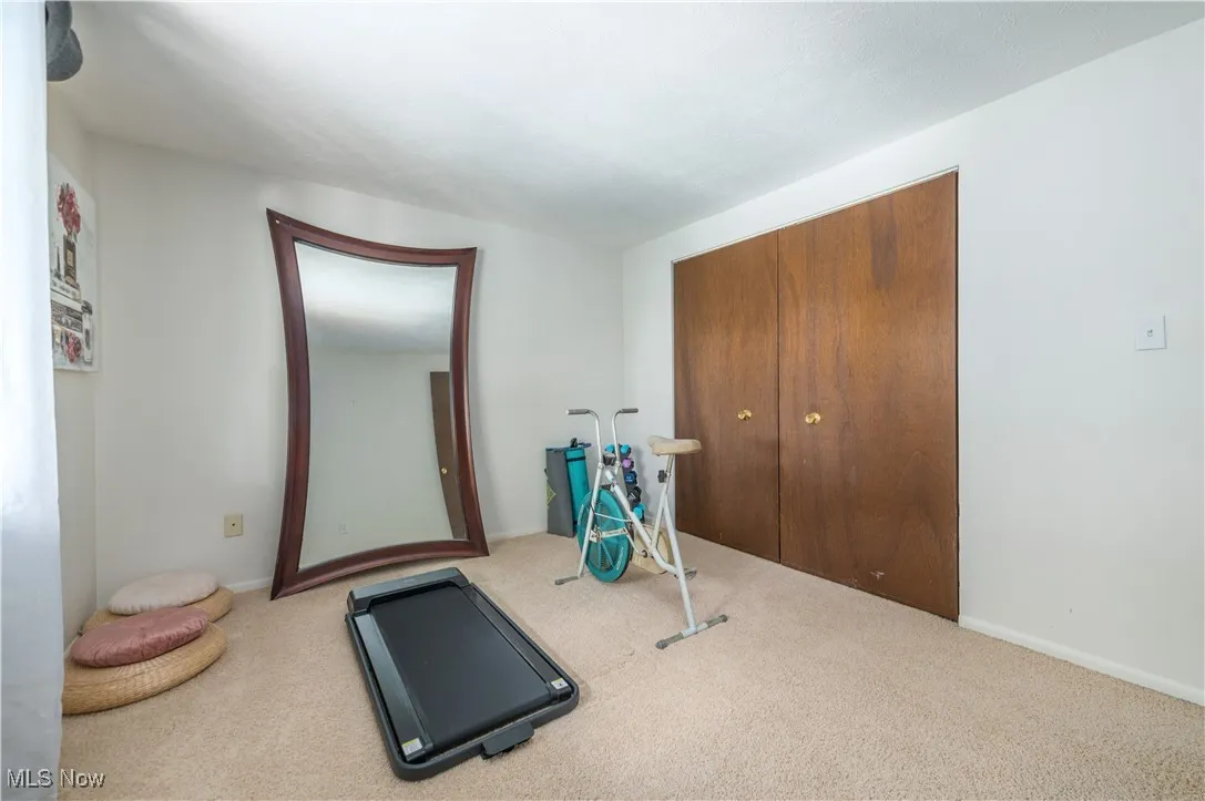 Workout room with carpet floors and baseboards