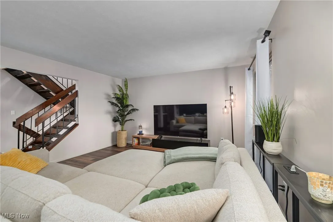 Living room with wood finished floors and stairway