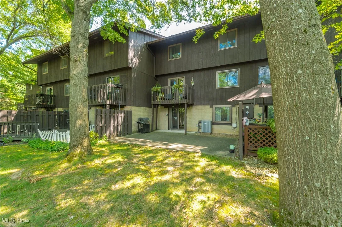 Back of property with a patio area, a yard, and a balcony