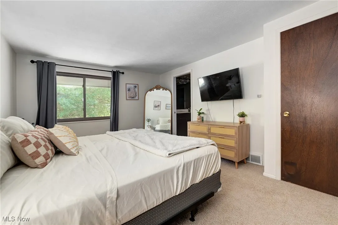 Bedroom with light colored carpet and ensuite bath