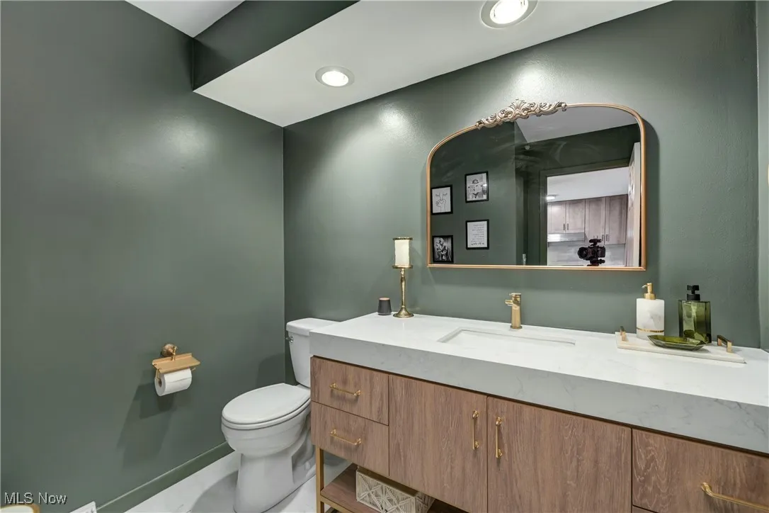 Half bathroom featuring vanity and toilet