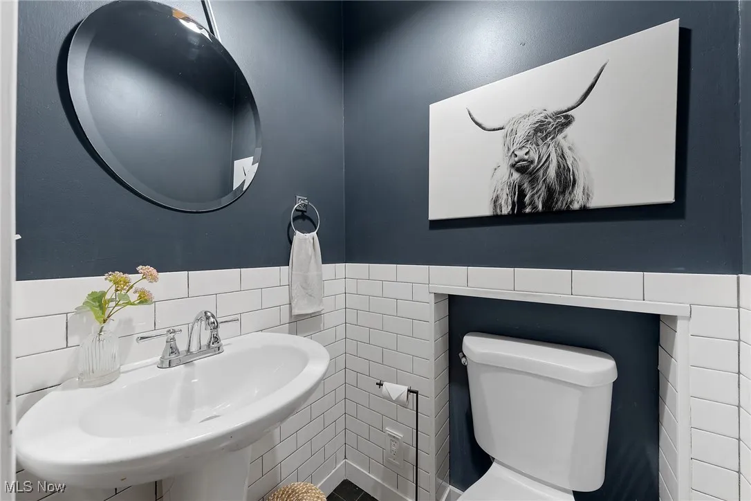 Bathroom featuring tile walls and a wainscoted wall