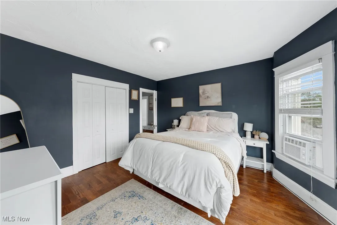 Bedroom featuring dark wood finished floors and a closet