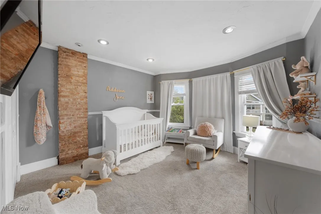 Bedroom featuring crown molding, a nursery area, light colored carpet, and recessed lighting