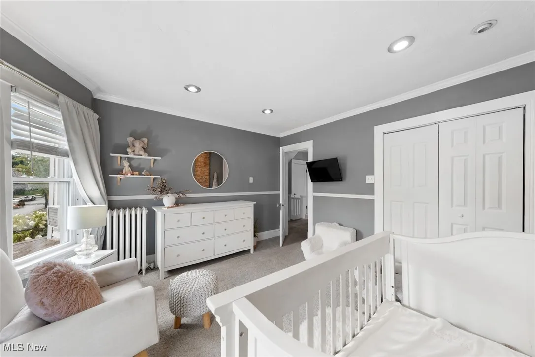 Bedroom featuring carpet flooring, crown molding, radiator heating unit, a closet, and recessed lighting