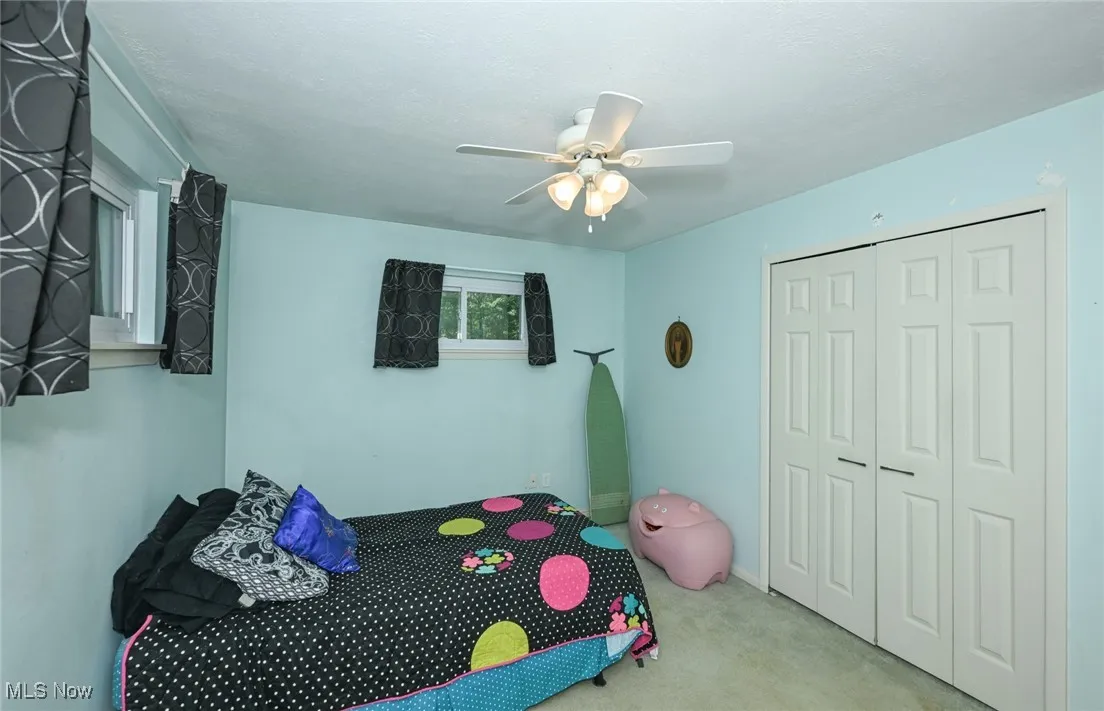 2nd bedroom with carpet and ceiling fan.