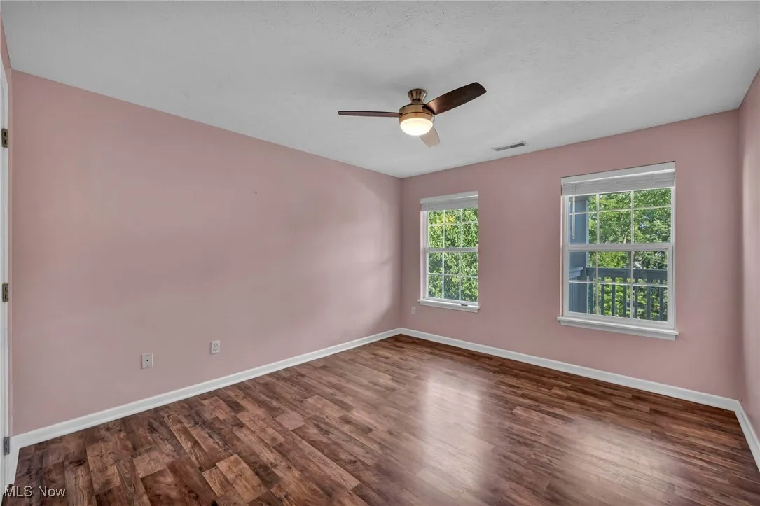 Spare room featuring wood finished floors, a ceiling fan, and a textured ceiling