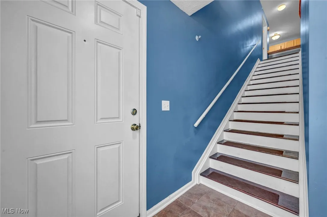 Stairs featuring baseboards and tile patterned floors